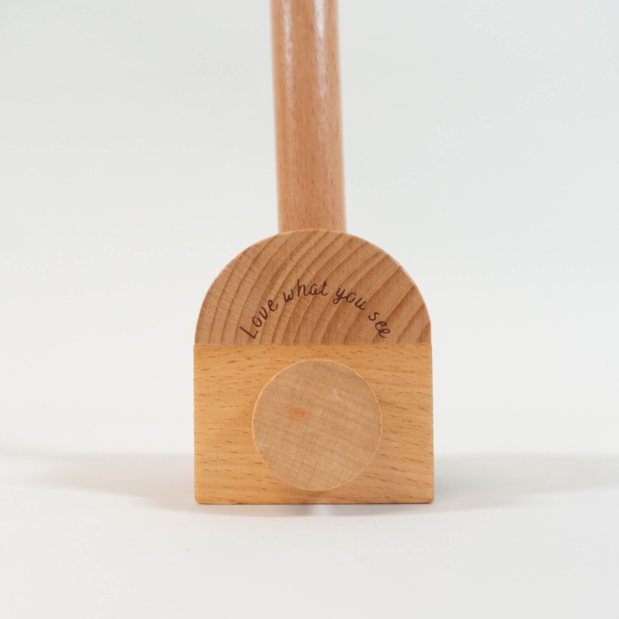 A zoomed in view of the base of the wooden mobile arm with the engraving "love what you see".