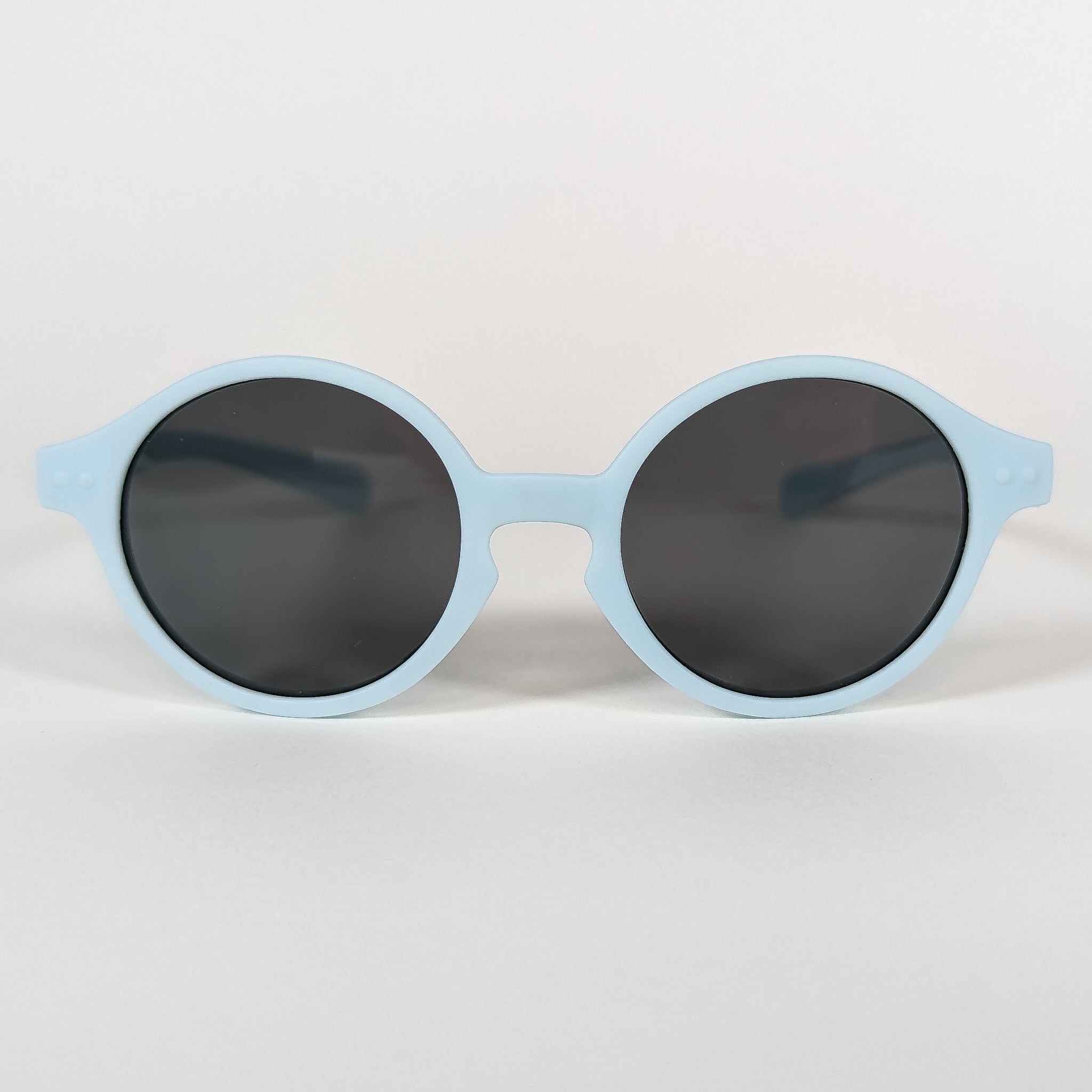 Zoomed in view of baby sunglasses with a blue frame and round lenses.