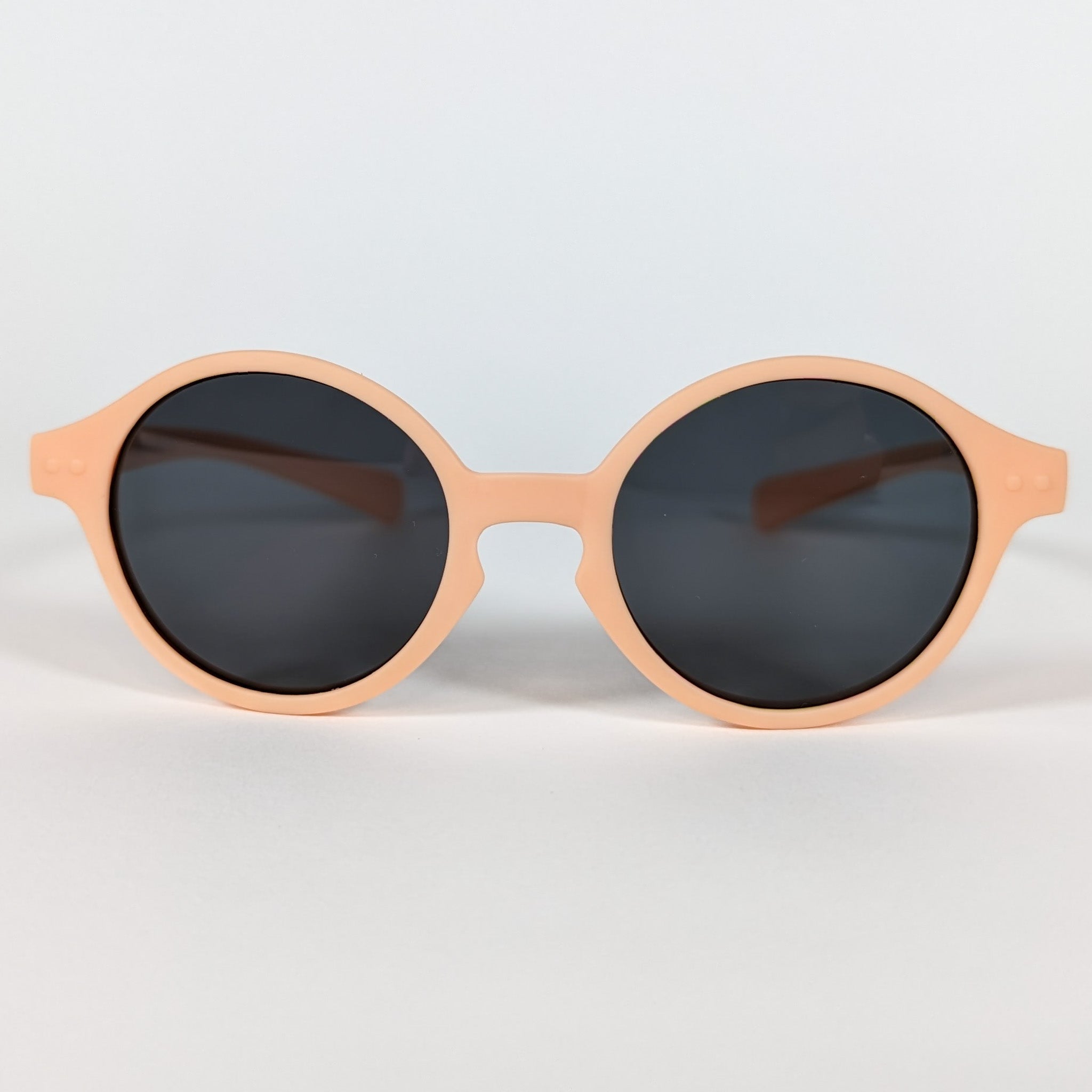 Zoomed in view of baby sunglasses with an orange frame and round lenses.