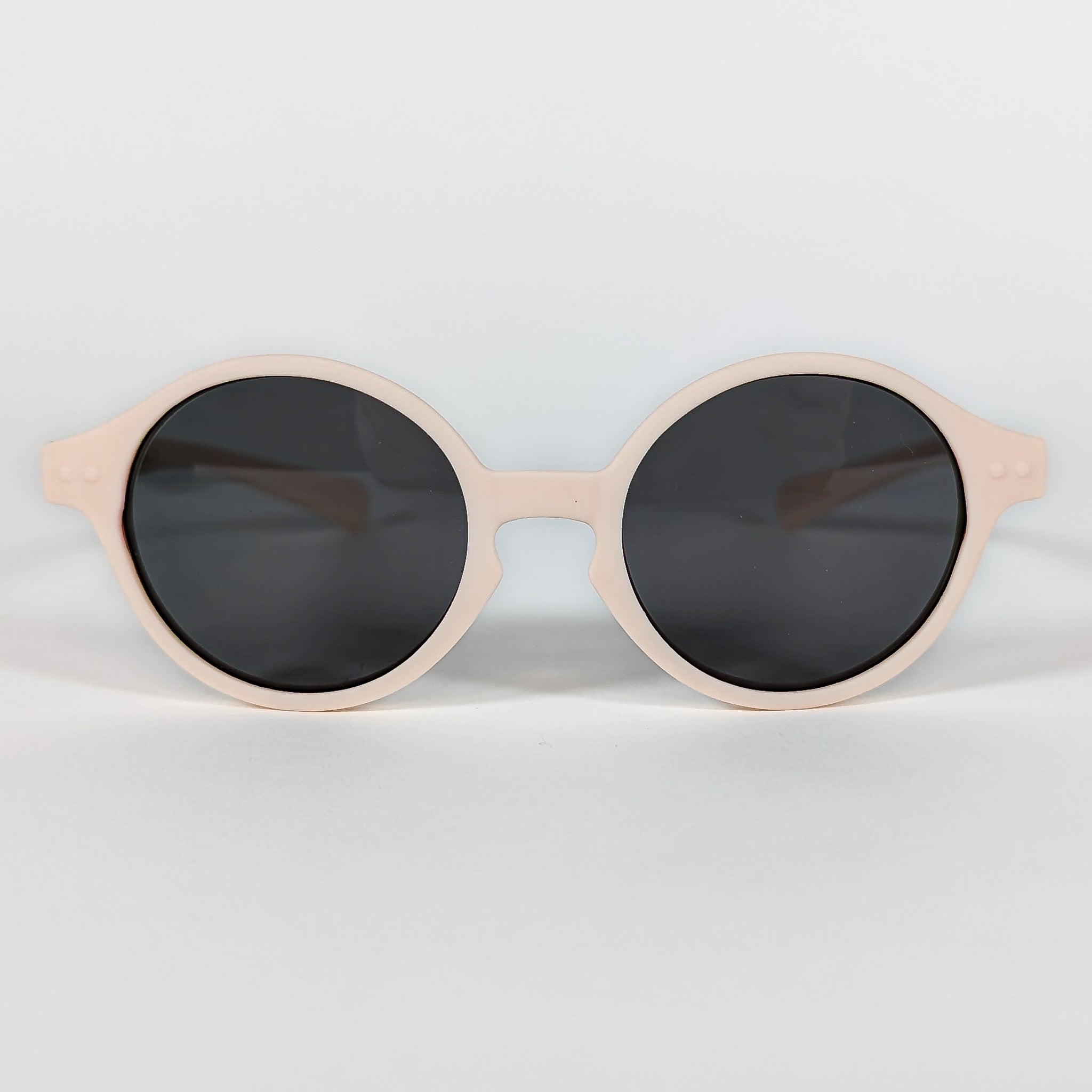 Zoomed in view of baby sunglasses with an ivory frame and round lenses.