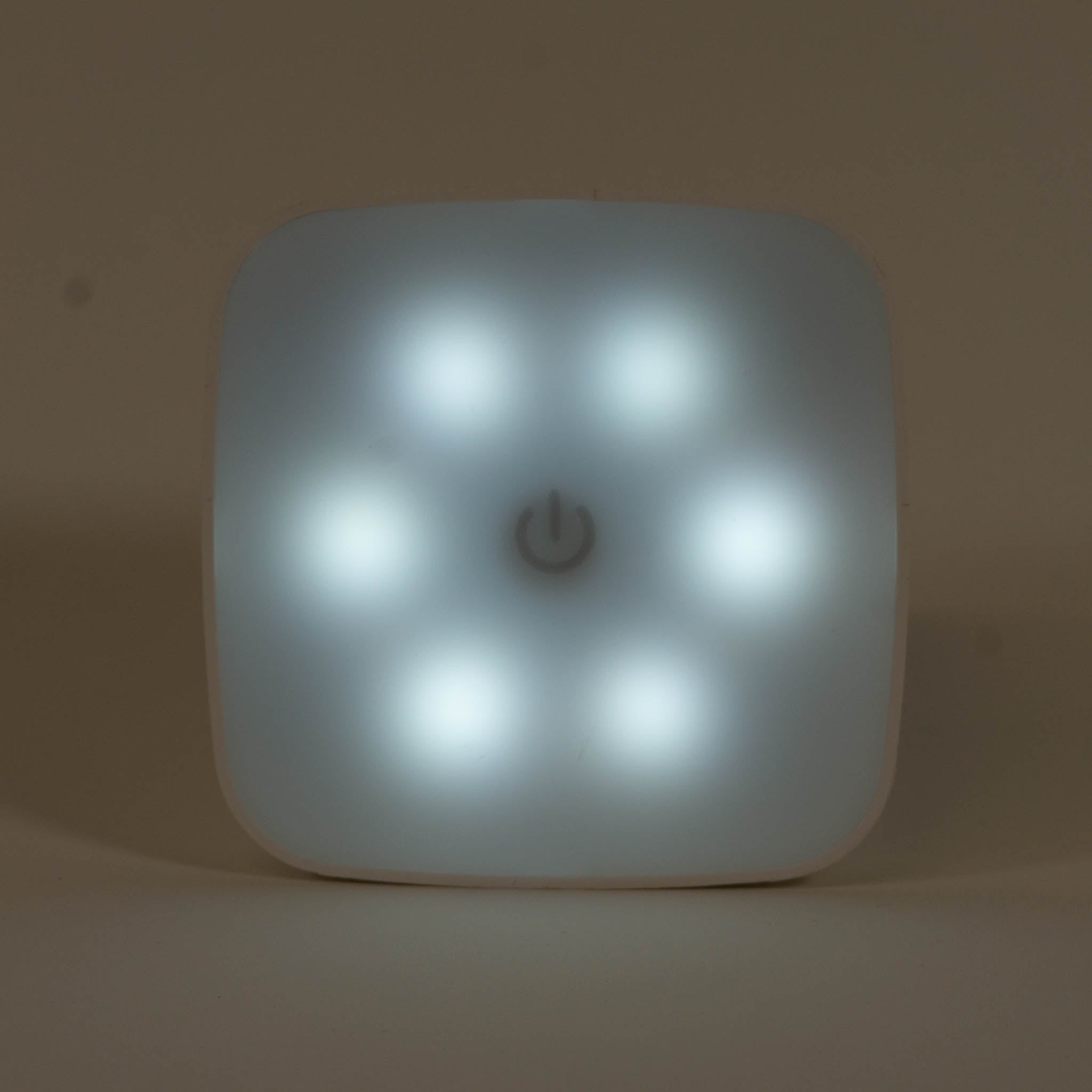 A zoomed in photo of a square night light showing a cool white hue.