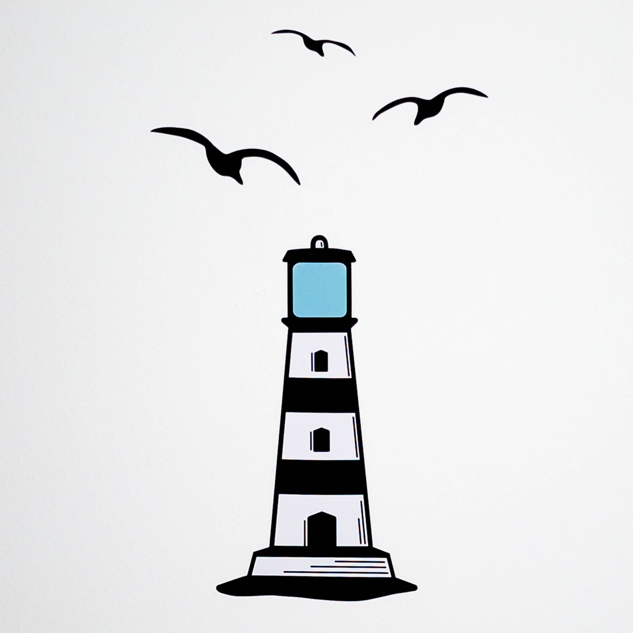 A white background with a black and white lighthouse wall decal and 3 black seagulls.