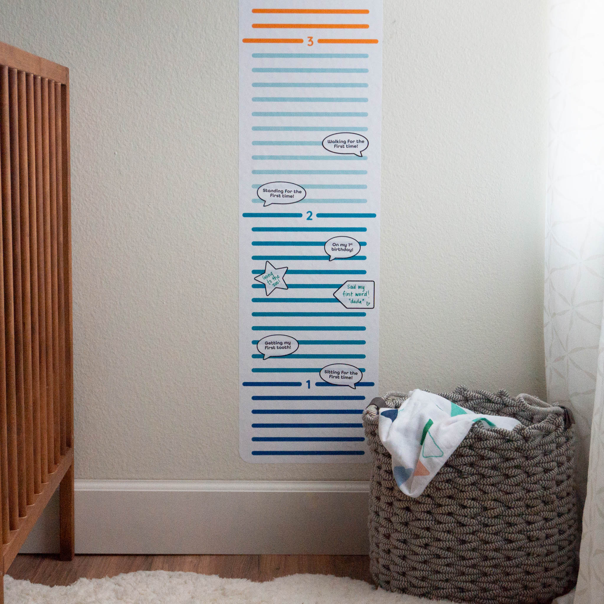 Child's nursery with Smartbaby Decor's growth chart wall art on the wall, showing multiple add on stickers marking key life events like a birthdays.