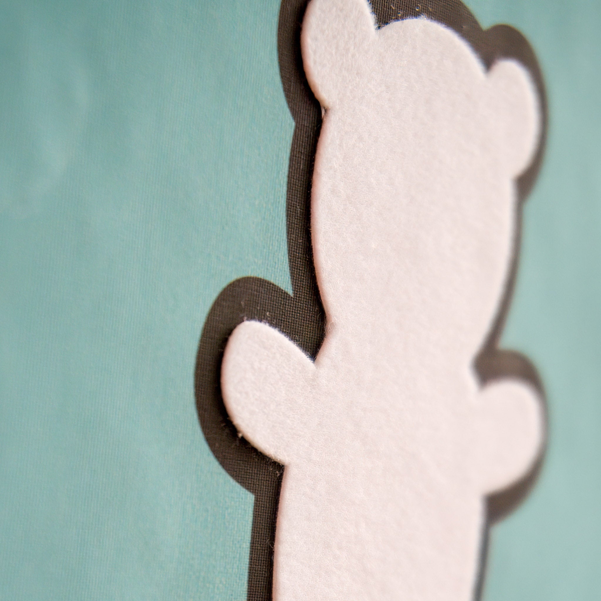 A zoomed in photo showing the raised velvet from the flat wall decal in the shape of a teddy bear