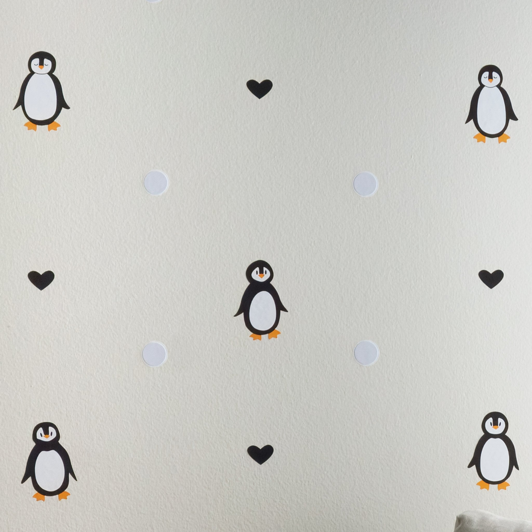 Alternating penguin, black heart and sensory snowball wall art decals on wall